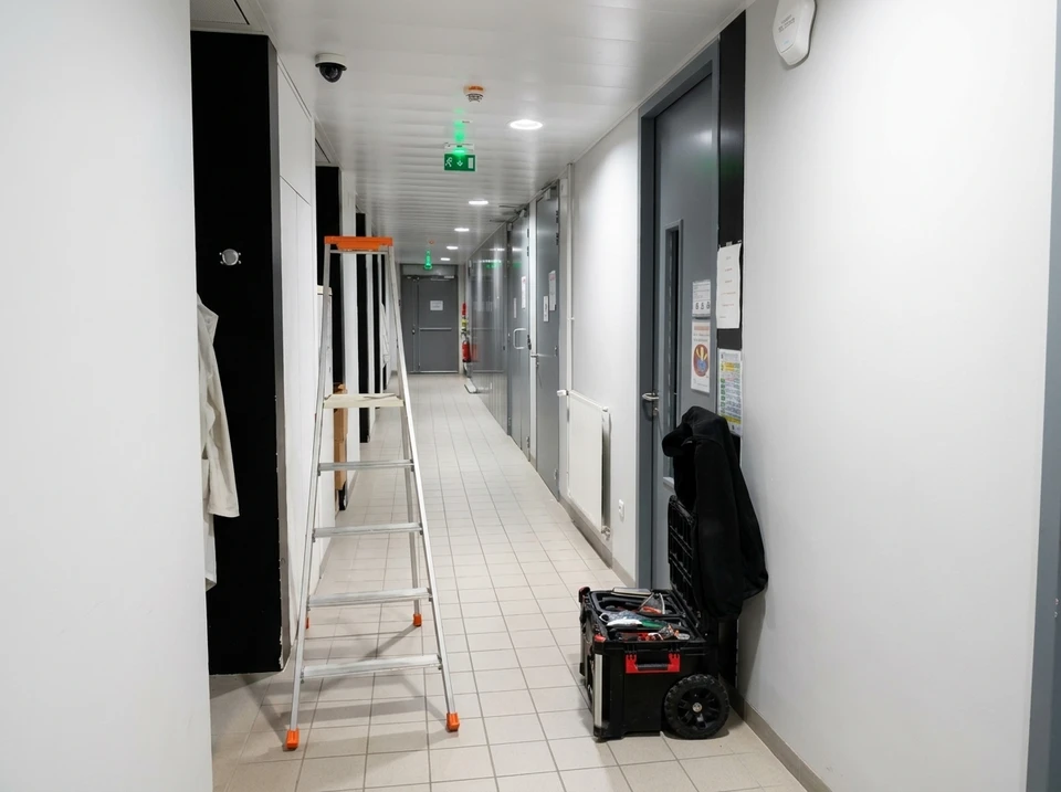 Chantier de construction extérieur avec ouvrier en équipement de sécurité haute visibilité consultant un smartphone